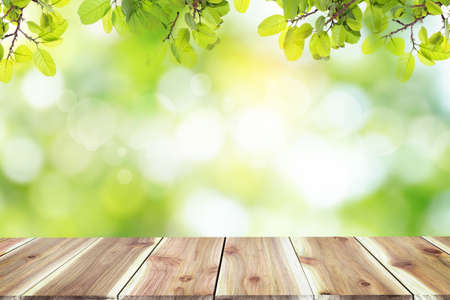 Empty wooden table with blurred city park on background The top has a natural  bokeh light,Mock up for display.  montage of product,Banner or header for advertise on social media,Spring and Summer.の写真素材