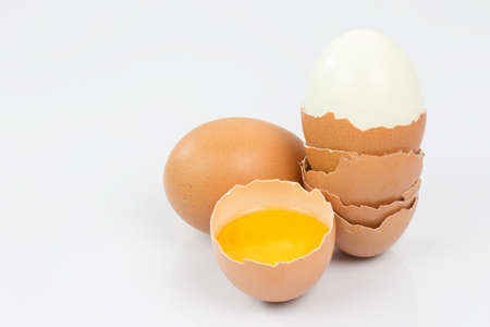 Chicken eggs and half with yolk on a white background.