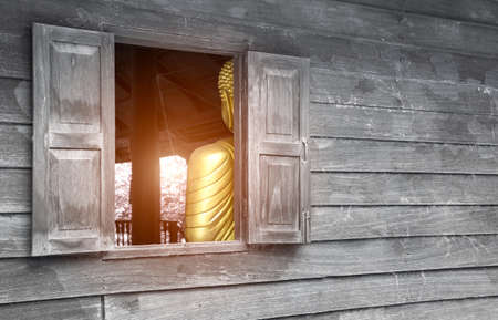 Old wooden wall with window inside, there is a Buddha representing the Buddha. The problem is that...