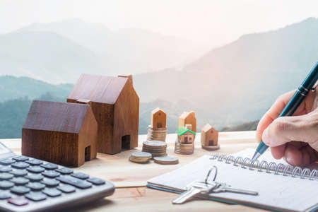 House placed on coins Men's hand is planning savings money of coins to buy a home concept concept for property ladder, mortgage and real estate investment.  for saving or investment for a house,の写真素材