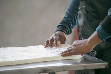 Rubber production. man working machine rubber sheet in the small rubber factory,