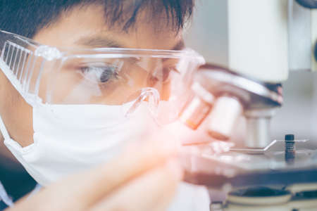 Young Asian Scientist are certain activities on experimental science like mixing chemicals or entry data to develop medicine, foods for everyone on the world, film effect.の写真素材
