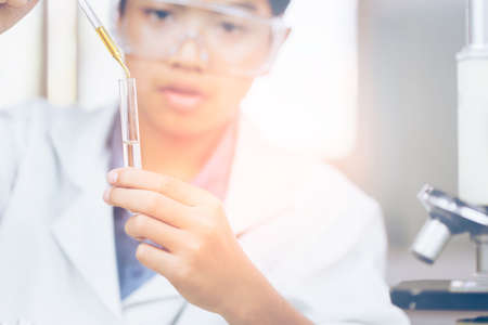 Young Asian Scientist are certain activities on experimental science like mixing chemicals or entry data to develop medicine, foods for everyone on the world, film effect.の写真素材