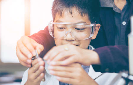 Science teachers are testing the effects of chemistry on school children.science like mixing chemicals or entry data to develop medicine, foods for everyone on the world, film effect.の写真素材