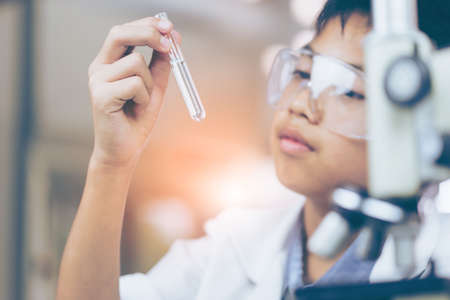 Young Asian Scientist are certain activities on experimental science like mixing chemicals or entry data to develop medicine, foods for everyone on the world, film effect.の写真素材