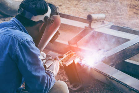 Worker welder working welding steel in industry with safety mask safety gloves and safety equipment....