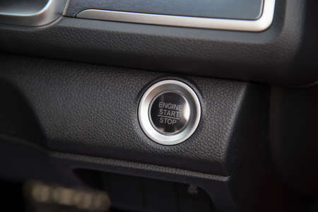 Car start stop system with finger pressing the button, horizontal image