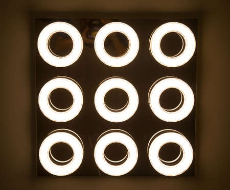 led light bulb in the industrial lamp is bright on the ceiling of the new warehouse with copy space,...