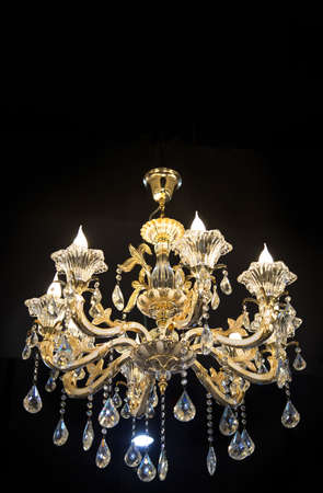 Close up on crystal of contemporary chandelier, is a branched ornamental light fixture designed to be mounted on ceilings or walls. Black backgroundの写真素材
