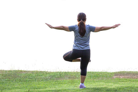 Young woman is practicing yoga at Lawn, park. isolated on White Backgroundの写真素材