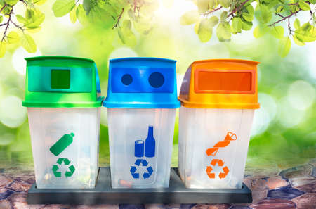 green, yellow, blue and recycle bins with recycle symbol isolated on Natural bokeh background. Concept for the environmentの写真素材