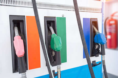 Colorful Petrol pump filling nozzles isolated on white background , Gas station in a service in warm sunsetの写真素材