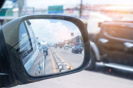 Cars run through the street from the Gray car's side view mirror.  city beside. Road Car Rear View Mirror Motion Blur Background (Vintage Style)の写真素材