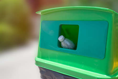 throwing empty plastic bottle into the trash Recycling Concept. Selective focus throwing empty plastic bottle into the trashの写真素材