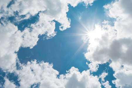 Sunny background, blue sky with white clouds and sun. The natural blue background has a breeze on a bright day in the summer.The sky and clouds are not the same shape as the weather.の写真素材