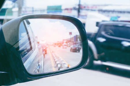 Cars run through the street from the Gray car's side view mirror.  city beside. Road Car Rear View Mirror Motion Blur Background (Vintage Style)の写真素材