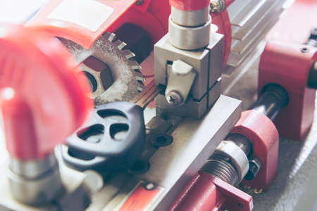 Locksmith in workshop makes new key. Professional making key in locksmith. Machine production of...