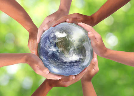 Conceptual symbol of multiracial human hands surrounding the Earth globe. Unity, world peace,...