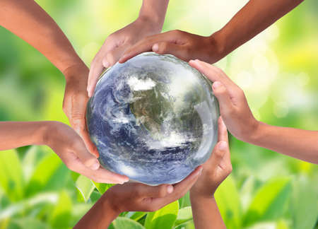 Conceptual symbol of multiracial human hands surrounding the Earth globe. Unity, world peace, humanity concept. World environment dayの写真素材