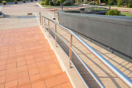 Concret ramp way with stainless steel handrail with disabled for support wheelchair disabled people.の写真素材