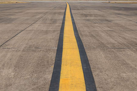 Yellow line painting on taxiway to guide pilot of airplane to drive at the airportの写真素材