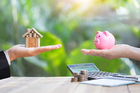 Real estate agents hold home for customers. Ideas for real estate, moving houses or renting real estate.Businessmen catch the key.For home trading.There is space for entering text.の写真素材