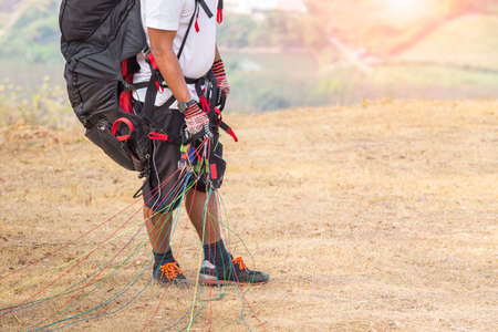 Paraglider on the ground. paragliders with full flight equipment look on soaring another paragliders atの写真素材