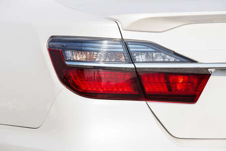 Closeup of car tail light on a white car. Generic brandless sports car taillights detail.