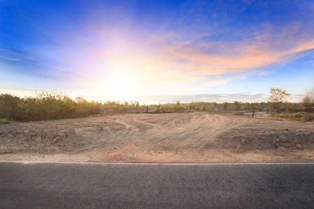 Empty dry cracked swamp reclamation soil, land plot for housing construction project with car tire print in rural area and beautiful blue sky with fresh air Land for sales landscape conceptの写真素材