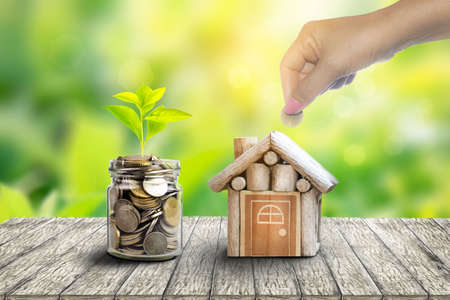 Plant Growing In Savings Coins. house and coin placed on the side. planning savings money of coins to buy a home concept for property, mortgage and real estate investment.to buy a house.の写真素材