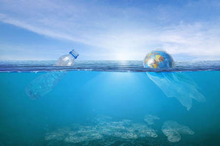 Creative background, World wrapped in plastic floating in the ocean, a bottle in the water. The concept of environmental pollution, non-decomposable plastic, increased debris in the world's oceans.の写真素材