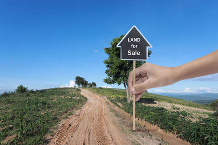 A sign advertises agricultural land for industrial use for sale, land plot for housing construction project  in rural area and beautiful blue sky with fresh air Land for sales landscape conceptの写真素材