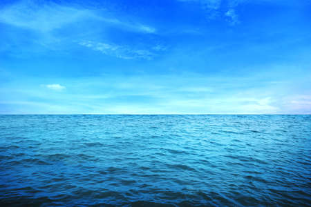 BLUE UNDER WATER waves and bubbles. Beautiful white clouds on blue sky over calm sea with sunlight reflection, Tranquil sea harmony of calm water surface. Sunny sky and calm blue ocean.の写真素材