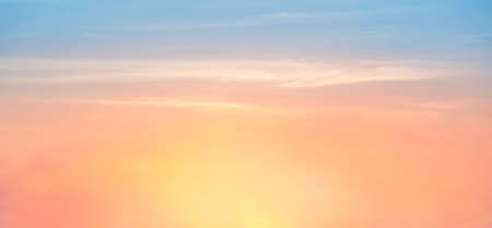 Beautiful sky painted by the sun leaving bright golden shades.Dense clouds in twilight sky in winter evening.Image of cloud sky on evening time.Evening sky scene with golden light from the setting sunの写真素材