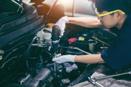 Auto mechanic working on car engine in mechanics garage. Repair service. Automotive Car repair conceptの写真素材