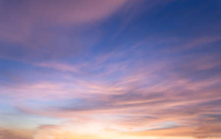 Beautiful sky painted by the sun leaving bright golden shades.Dense clouds in twilight sky in winter evening.Image of cloud sky on evening time.Evening sky scene with golden light from the setting sunの写真素材