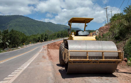 Roller rolling fresh hot asphalt on the new road. Road construction. The road rollers working on the new road construction siteの写真素材