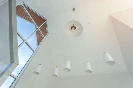 looking up on suspended ceiling with halogen spots lamps and drywall construction in empty room in apartment or house. Stretch ceiling white and complex shape.の写真素材