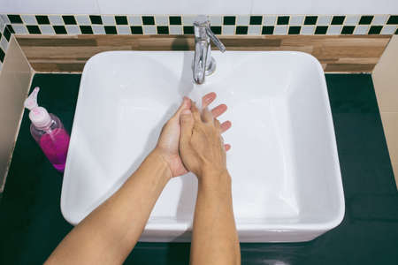 man are washing their hands with foam soap and clean water. Wash your hands to keep them clean and prevent the spread of viral. How to wash your hands for COVID-19 prevention.の写真素材