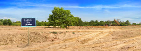 A truck is moving into sand at a ground leveling construction site., land plot for housing construction project with car tire print in rural area Land for sales landscape concept.の写真素材