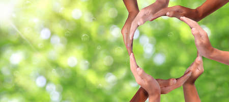 Conceptual symbol of multiracial human hands making a circle on  nature background with a copy space in the middle. conceptualization, hands-on for business and service, volunteering or teamwork,の写真素材