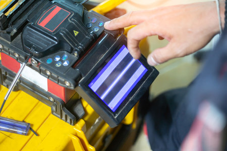 Banner template Technician Fiberoptic Fusion Splicing. Worker connecting for Cable Internet signal and Wire connection with Fiber Optic Fusion Splicing machine,fiber optic cable splice machine in workの写真素材