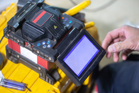 Banner template Technician Fiberoptic Fusion Splicing. Worker connecting for Cable Internet signal and Wire connection with Fiber Optic Fusion Splicing machine,fiber optic cable splice machine in workの写真素材