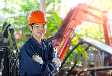 Portrait Professional Mechanic repairing hydraulic hose in machinery factory. Young Asian engineering man wearing helmet industrial worker on Hydraulic maintenance. look at camera at Hydraulic factoryの写真素材