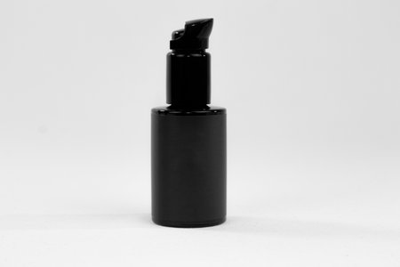 Product photo of a black bottle of natural cosmetics, on a white background, for mockupsの写真素材