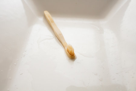 Wooden toothbrush on white bathroom sinkの写真素材
