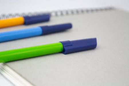 School notebook with markers above for back to school, green, blue and orange markers, with copy space, ideal for designs for back to schoolの写真素材