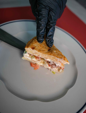 A chef's skilled hand presents a delectable portion of vegetable Spanish omelette, garnished with...