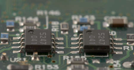 Closeup view of microchips on a circuit board; shallow depth of field.