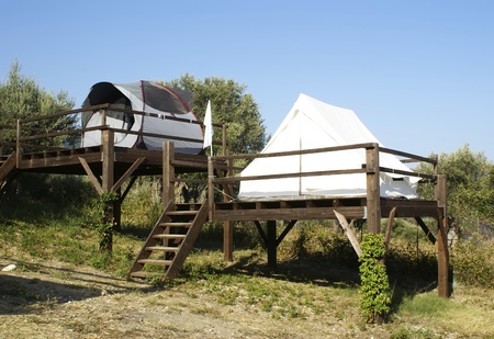 tents on stilts over the blue sky and countryside. Campingの写真素材